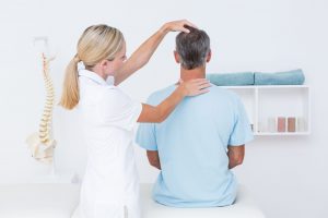 Female chiropractor treating male patient