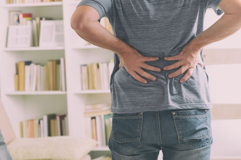 Man holding lower back in pain